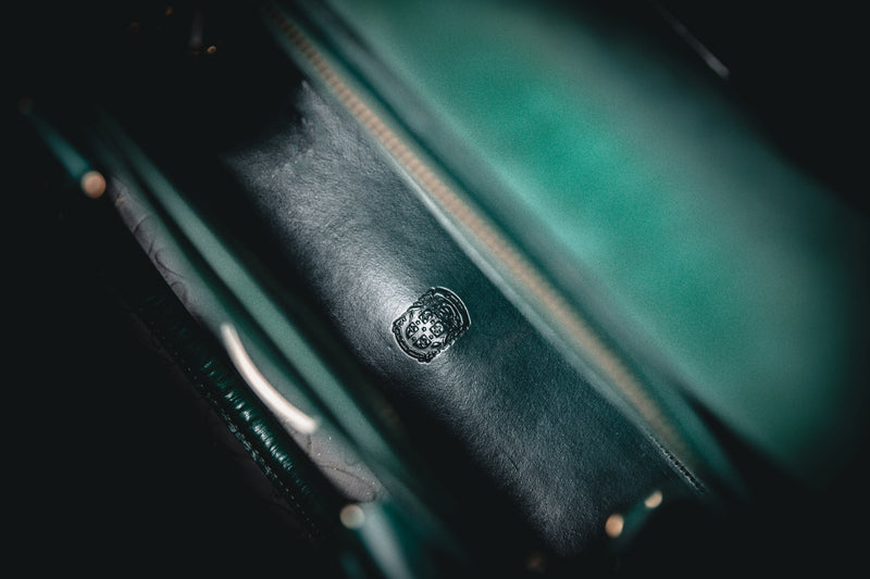 coupland crest close up on green leather ladies handbag