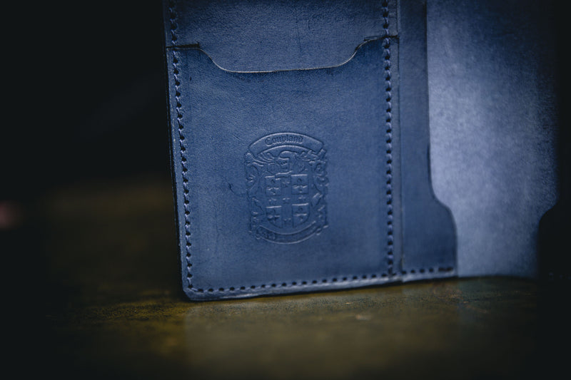 coupland crest close up on blue leather passport holder