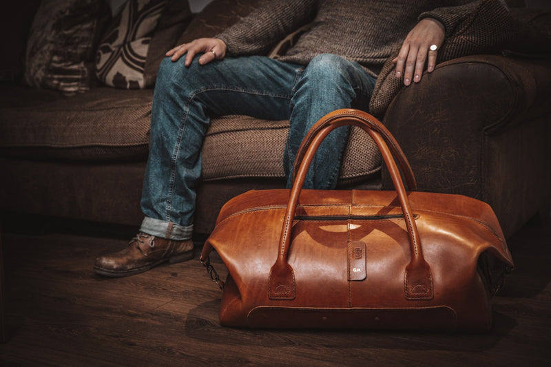 leather duffle bag close up with male in background