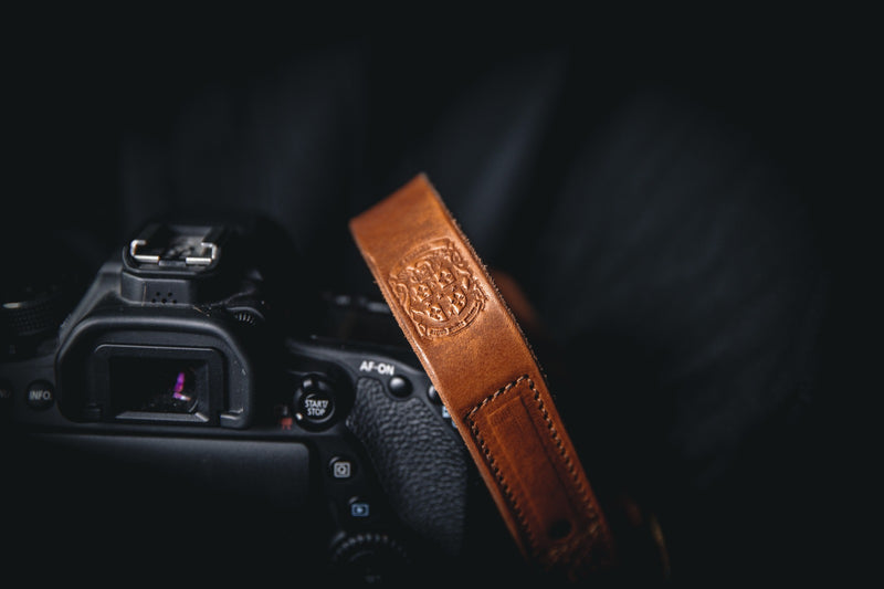 brown leather camera wrist strap with coupland crest attached to camera