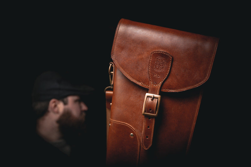 brown leather shotgun slip closed with leathersmith in the background